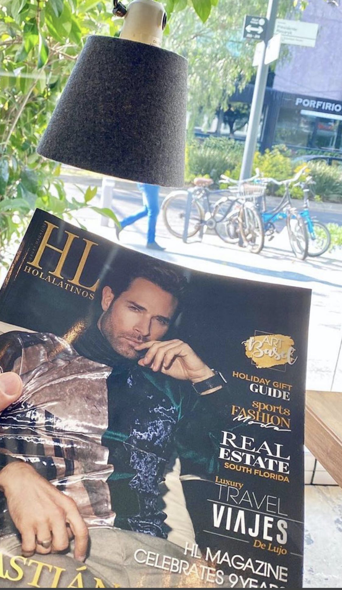 A man on the cover of a magazine titled "HUN" with jewelry and a city view behind.