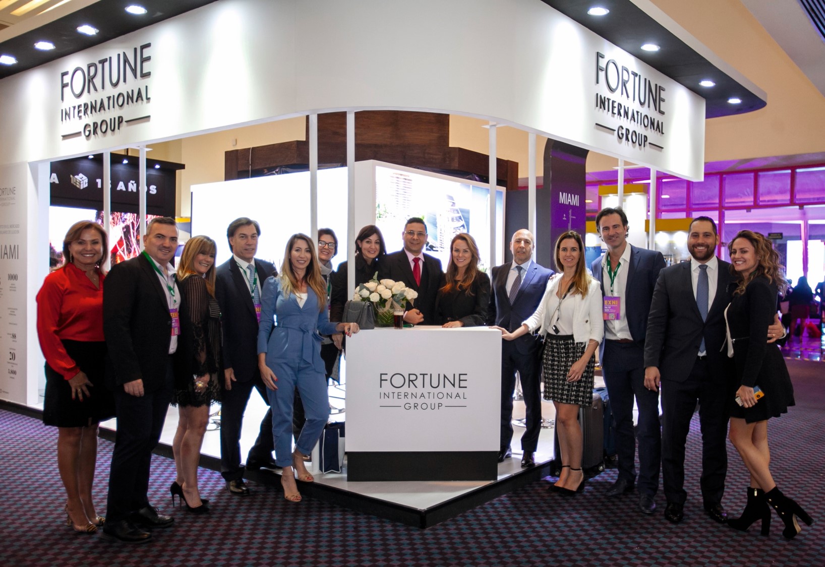 Group of professionals posing at Fortune International Realty booth.
