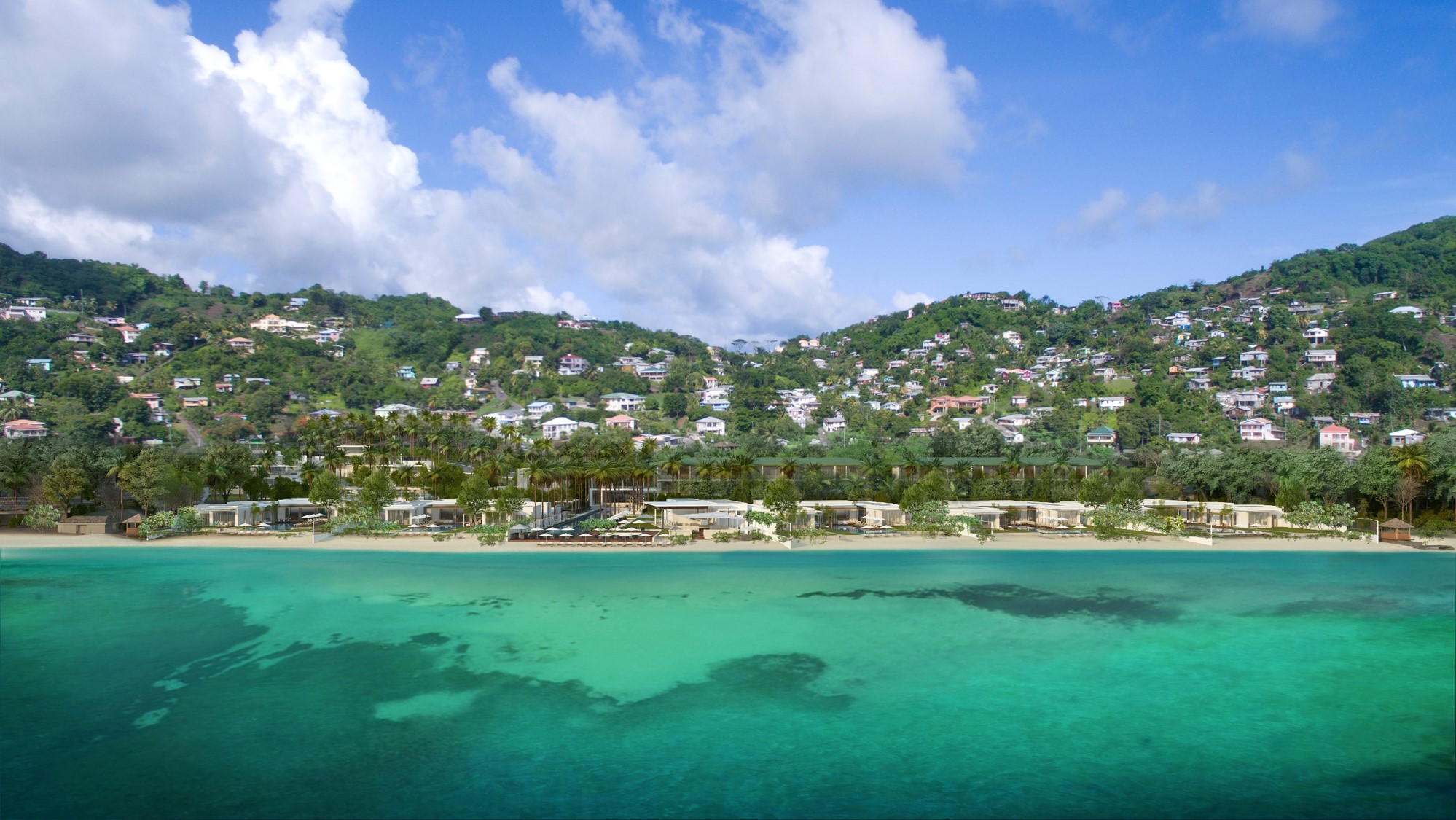 Tropical beach with clear turquoise water and hillside homes under a blue sky.