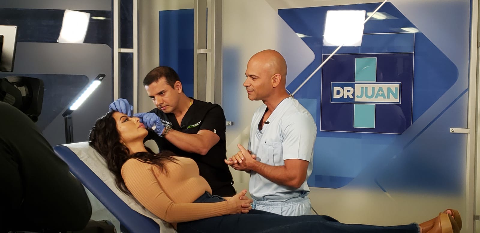 A person receiving a dental checkup from two professionals.