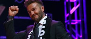 Man in a suit with a scarf at an event, smiling.