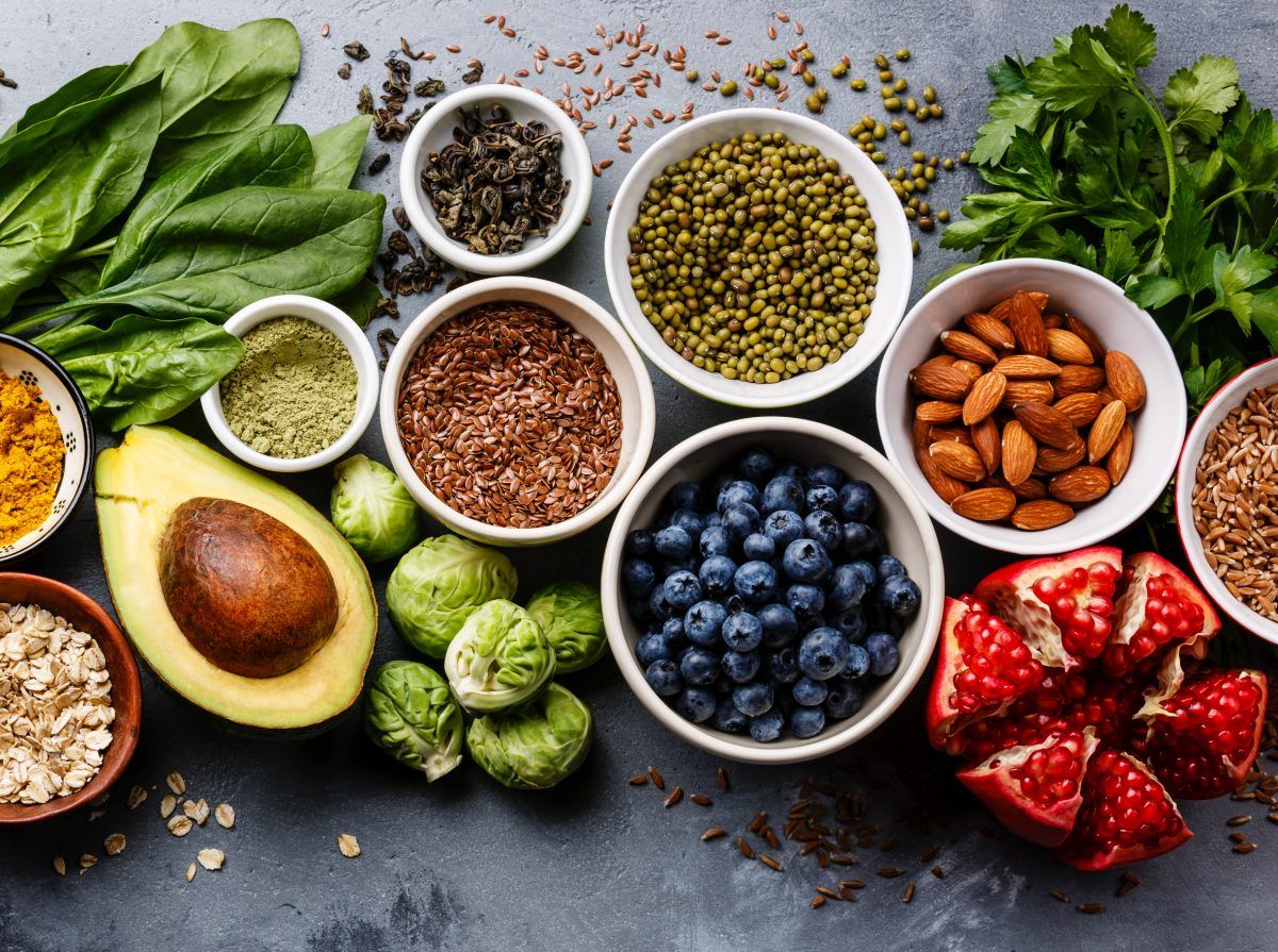 An assortment of fresh fruits, nuts, and seeds arranged in bowls.
