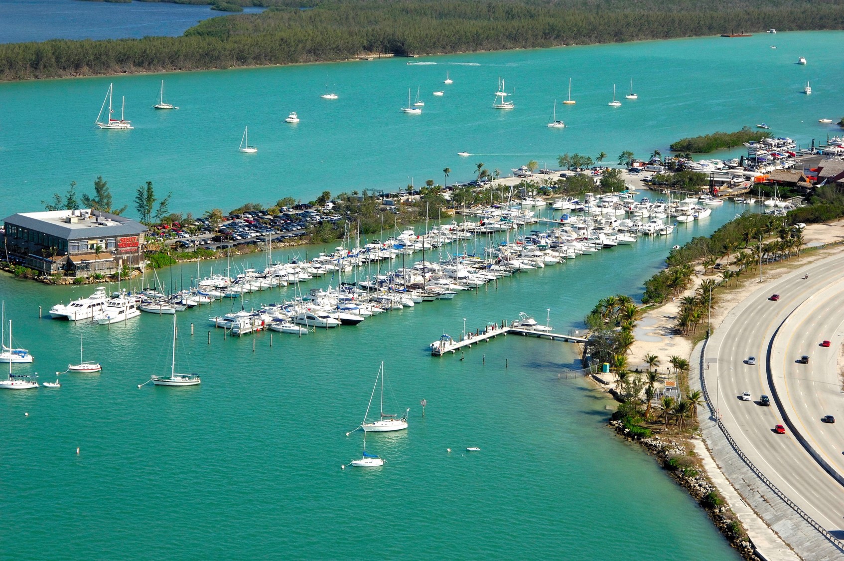 A marina with numerous boats docked in turquoise water.