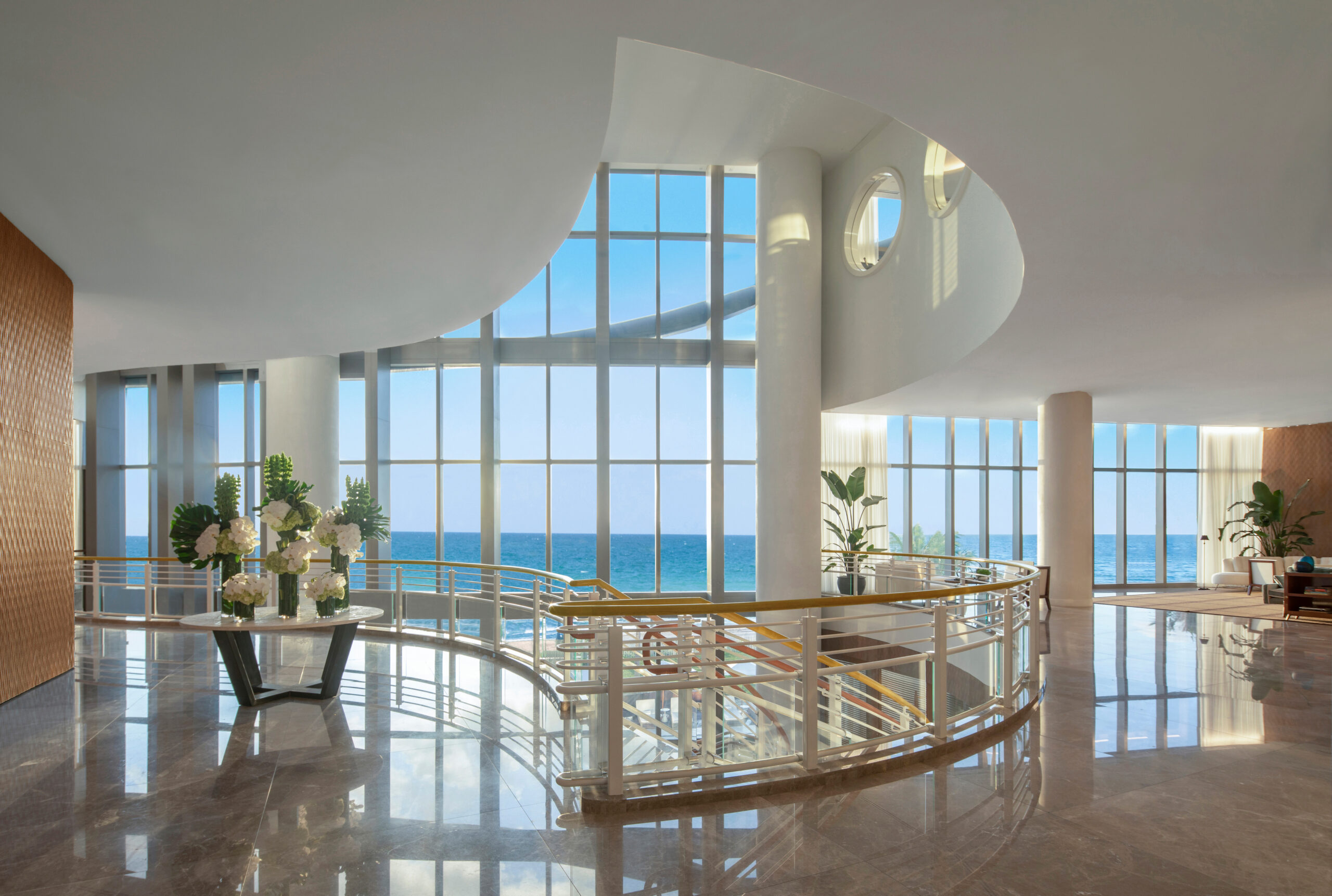 Elegant interior with ocean view through large windows.
