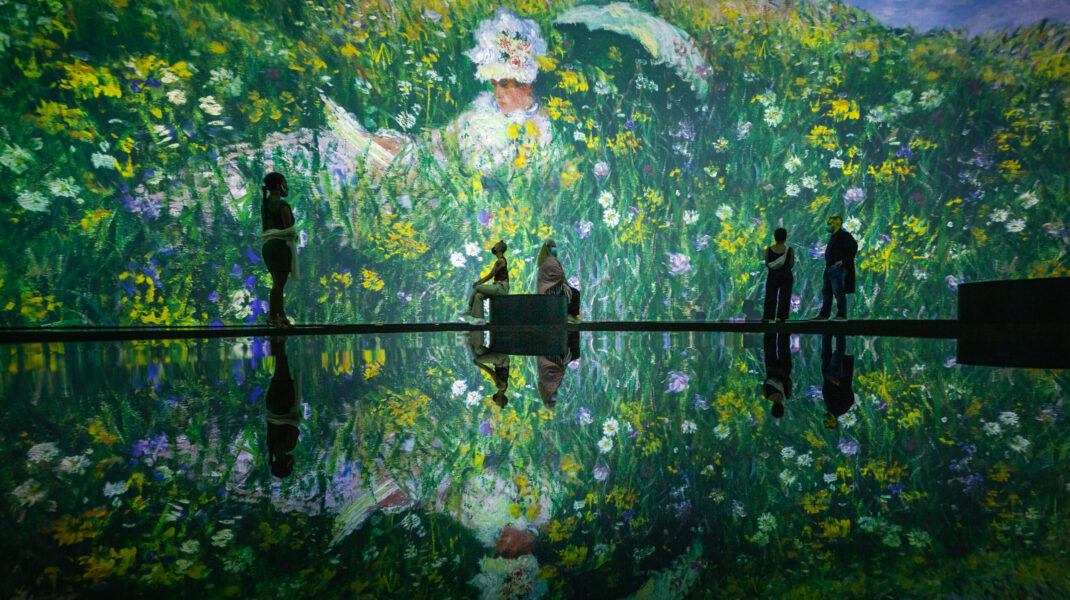 People enjoying an immersive floral art installation with reflections.