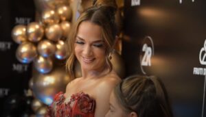 Woman in floral dress smiling at a child at a festive event.