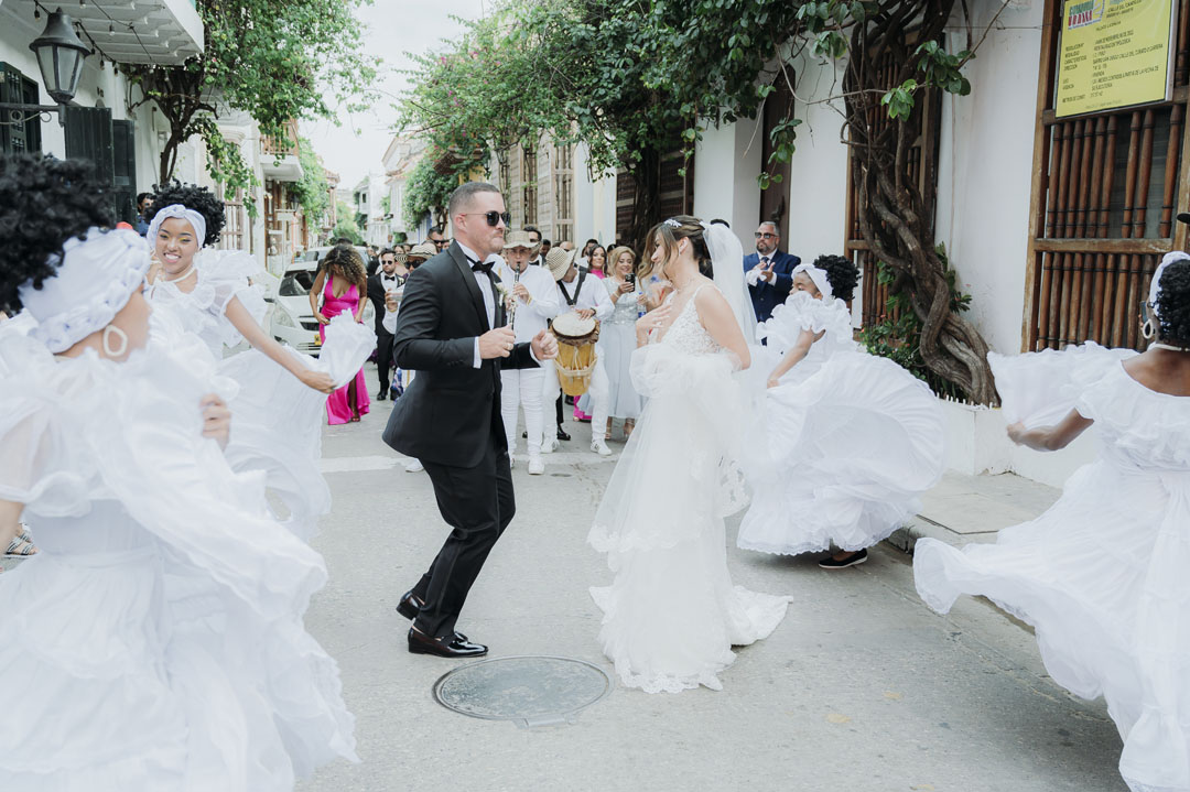 Guests joyfully dance at an outdoor wedding celebration.