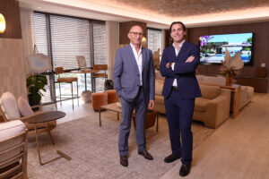 Two men in suits standing confidently in a modern office lounge.