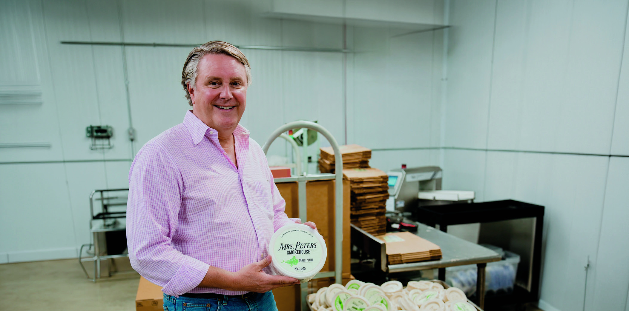 Geary Stonesifer holding a Mrs. Peters Smokehouse dip inside the smokehouse