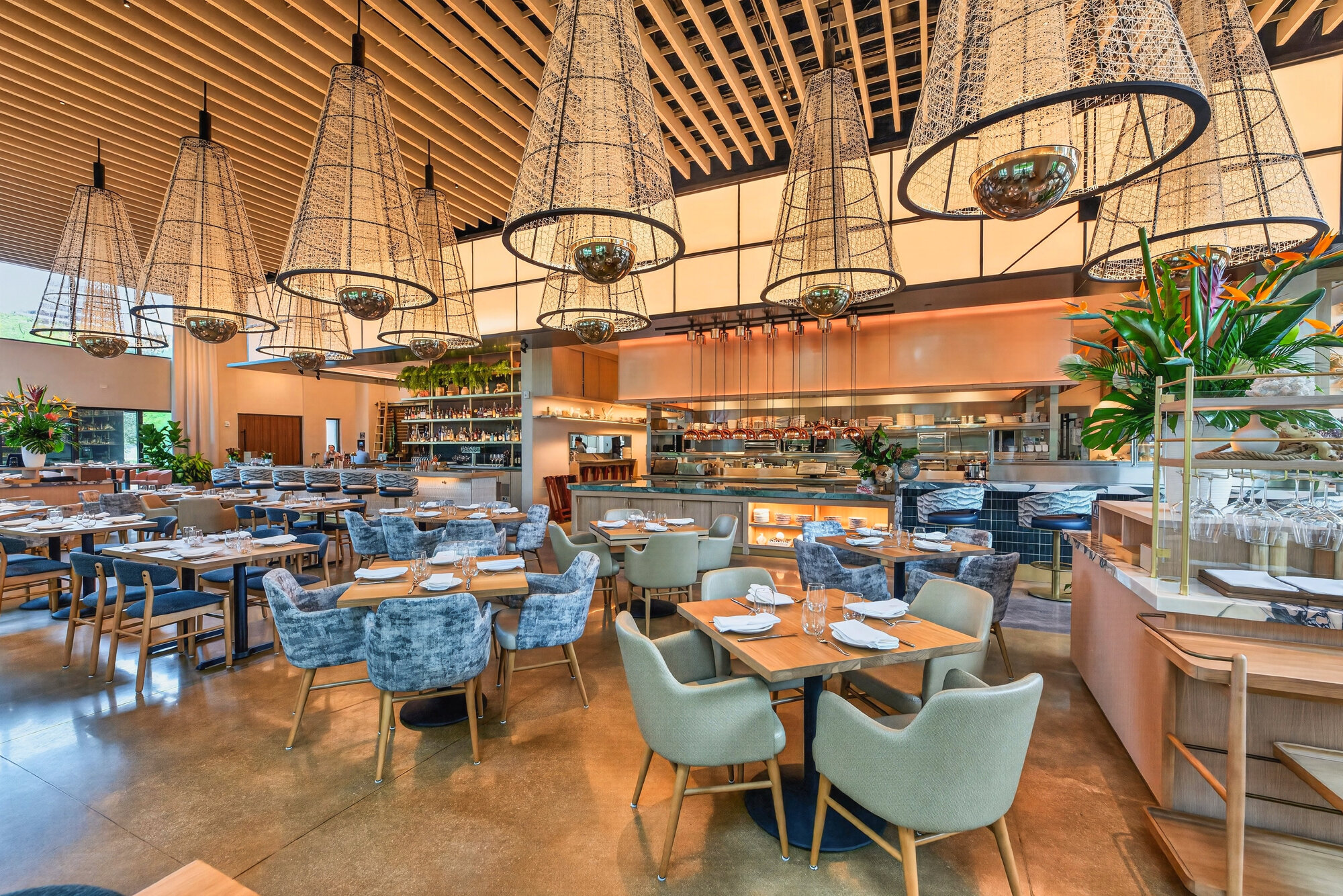 The main dining room at Sweetwaters with woven pendant lights and a view of the open kitchen