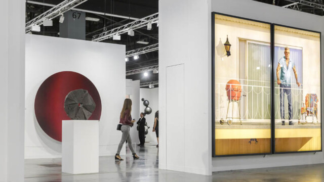 Visitors explore modern art exhibits in a spacious gallery.
