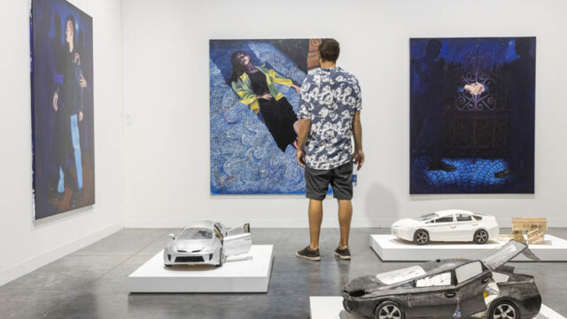 Man observing abstract art in a modern gallery.