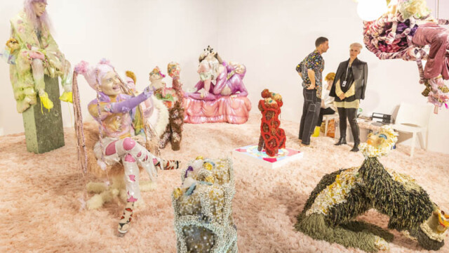 Intricate animal sculptures made from colorful materials displayed on a textured surface.