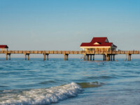 CLEAR WATER BEACH & CLEARWATER PIER
COURTESY: CITY OF CLEARWATER Pier with a red-roofed building extending over calm ocean waters.