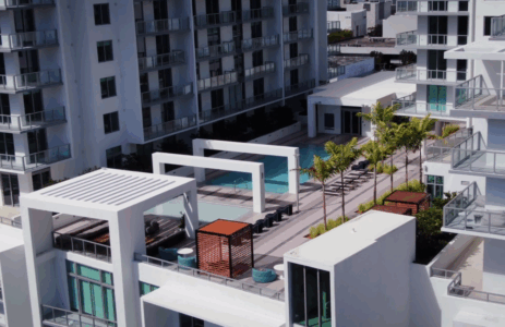 Modern apartment complex with rooftop amenities and pool.