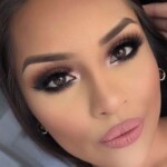 Close-up of a woman's face with glamorous makeup and soft pink lips.