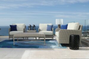 Outdoor seating area with wicker furniture and ocean view.