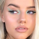 Close-up of a woman's face with flawless makeup and blue eyeshadow.