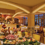 Elegant buffet setup in a warmly lit dining area with various dishes.