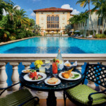 Breakfast served by a pool at a tropical resort.