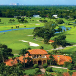 A scenic golf course with a clubhouse and water features.