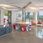 Modern living room with colorful furniture and coastal views.