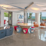 Modern living room with colorful furniture and coastal views.