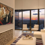 Modern living room with panoramic sunset views and elegant decor.