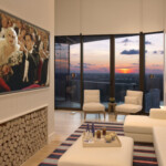 Modern living room with panoramic sunset views and elegant decor.