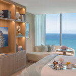 Modern bedroom with ocean view and elegant decor.