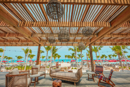 Outdoor lounge area with wooden pergola and tropical views.