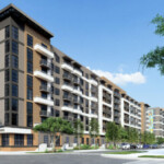 Modern multi-story apartment complex with balconies and surrounding greenery.