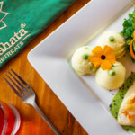 A gourmet dish with a flower garnish on a white plate.