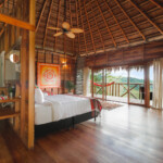 Cozy rustic bedroom with wooden accents and balcony view.