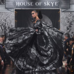 Model twirls in a flowing black gown at House of Skye fashion show.