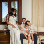Pregnant mother with husband and two children sitting by the window.