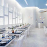 Bright, modern white dining area with sleek tables and chairs.