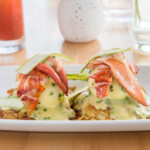 Delicious eggs Benedict topped with bacon and hollandaise sauce.
