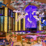Elegant dining room with vibrant lighting and floral decor.