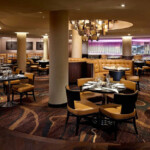 Elegant modern restaurant interior with round tables and warm lighting.