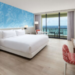 Modern hotel room with ocean view and balcony.