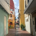 Colorful narrow street with vibrant buildings and hanging lights.