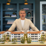 Man showcasing architectural models of residential buildings.