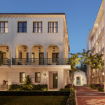Elegant building with arches and balconies under a clear sky.