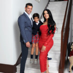 A stylish family poses on stairs, dressed elegantly.