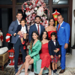 A large family dressed in festive attire posing indoors for a photo.
