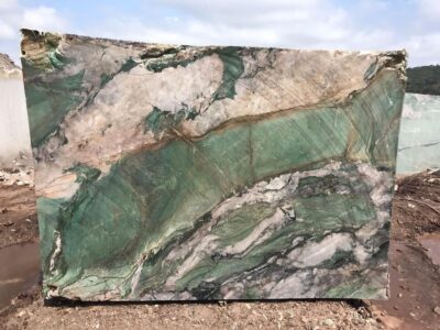 Close-up of polished green and beige marble with natural veining.