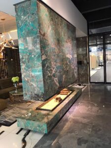 Modern lobby with marble walls and a sleek water feature.