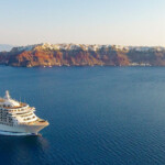 DCIM100MEDIADJI_0013.JPG Luxury cruise ship sailing near a scenic volcanic island at sunset.
