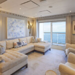 Elegant living room with beige furniture and ocean view.